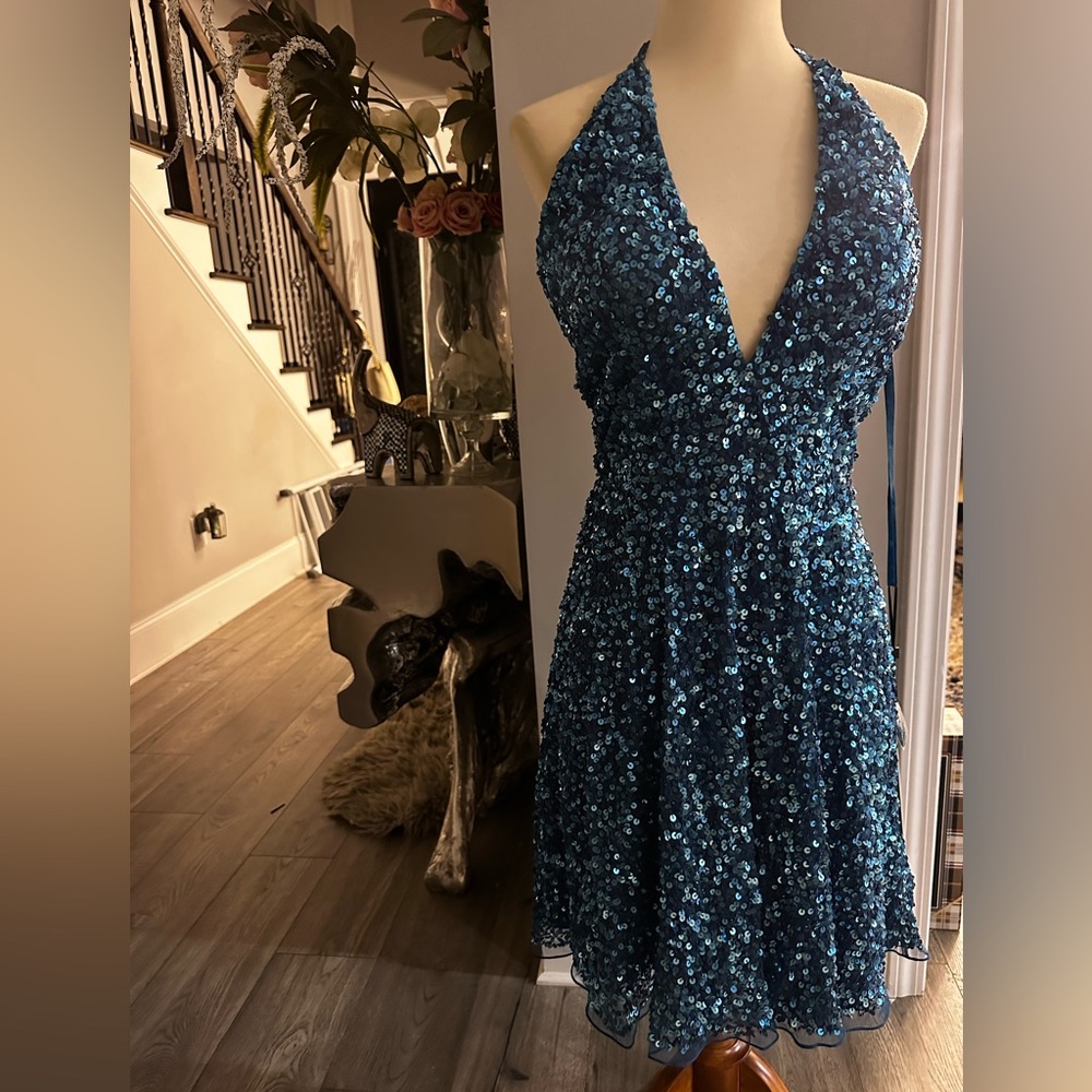 halter with a v-neckline cocktail dress features an intricate sequins material.